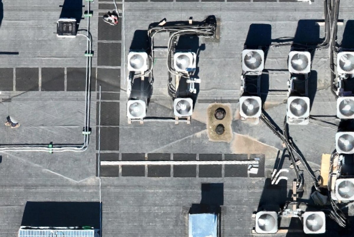 Orthomosaic detail of twin roof drains in a tapered sump, with condensing units on sleepers, condensate and refrigerant lines, and walkway pads